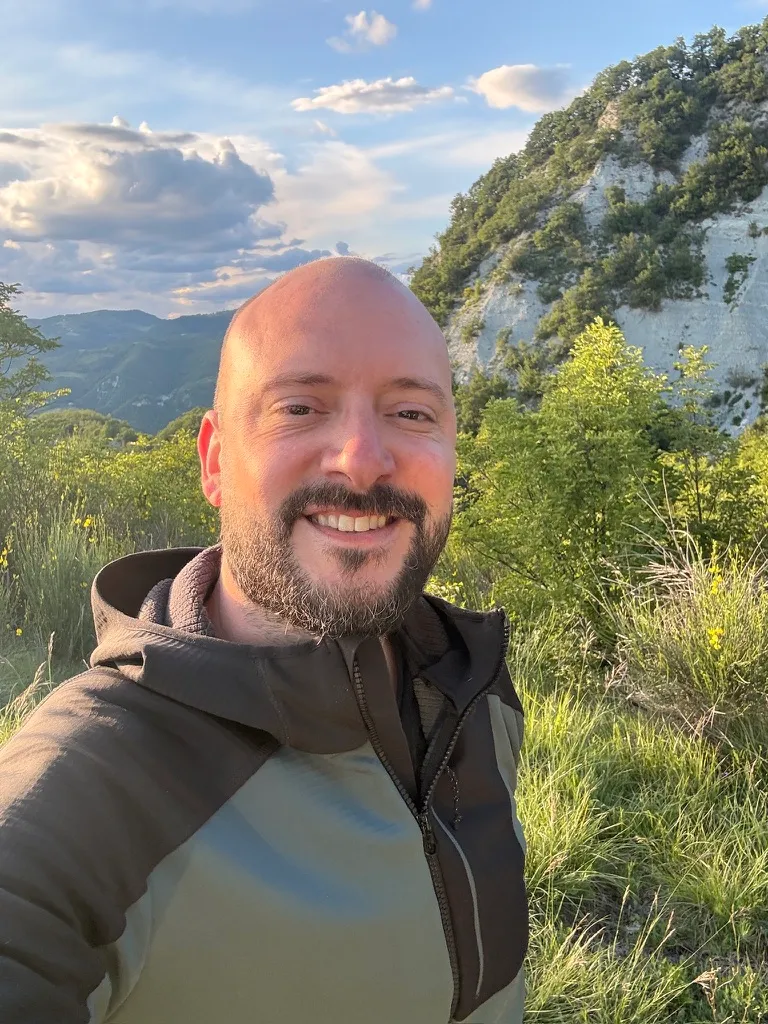 Sébastien Balieu sourit en randonnée, montagne en arrière-plan