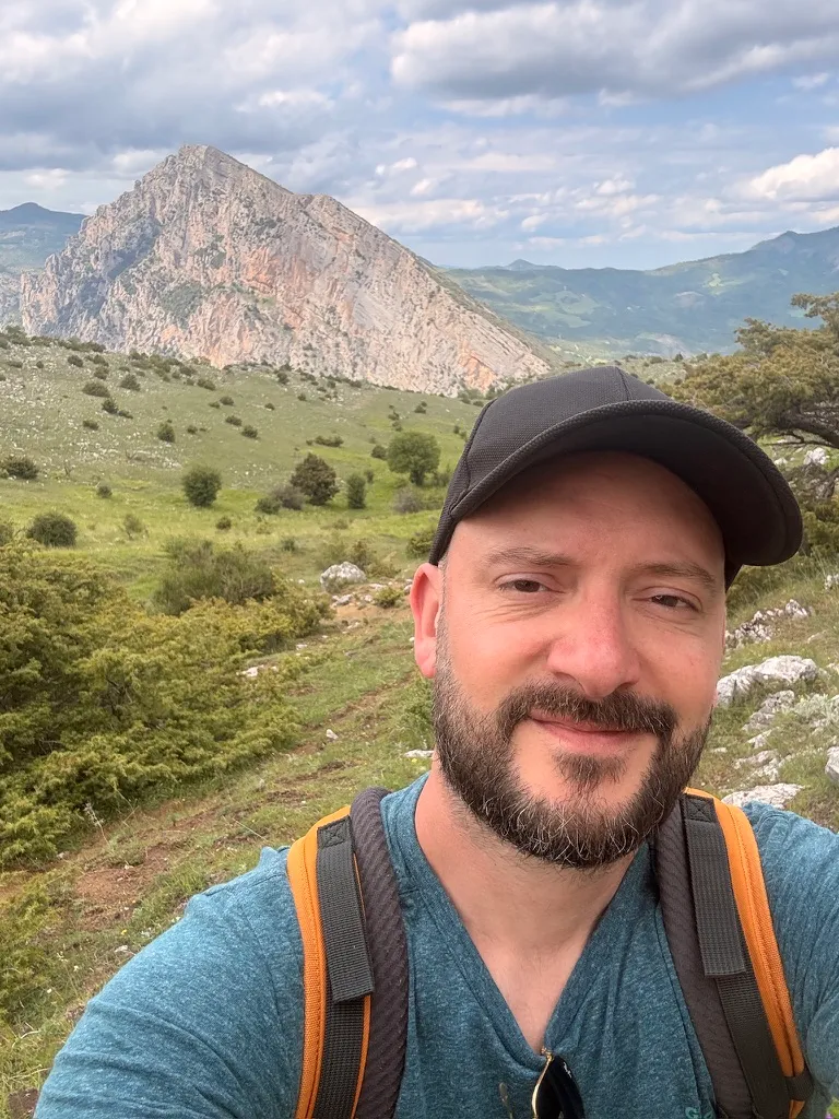 Selfie of Sébastien Balieu hiking in front of a rocky summit